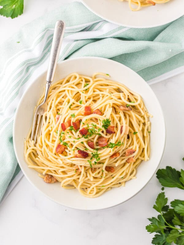 overhead view of spaghetti carbonara in a white bowl.