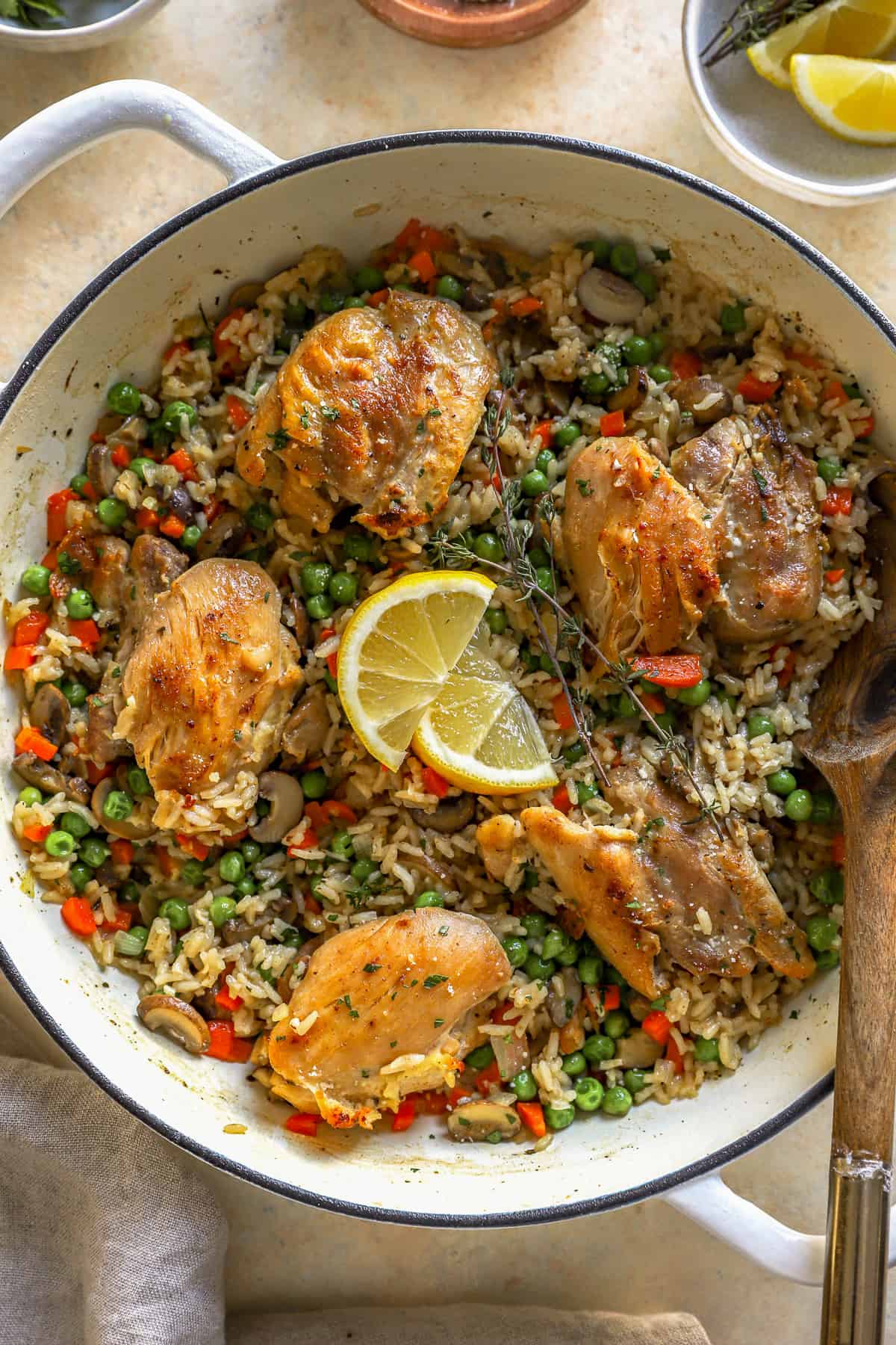 overhead view of chicken and rice in a dutch oven with a wooden spoon.