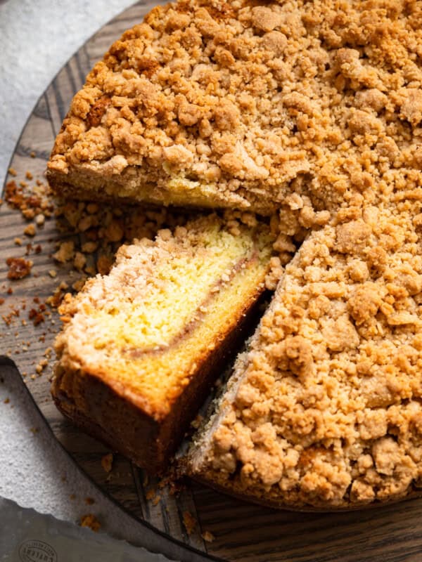 three-quarters view of cake mix coffee cake on a cake plate with one slice cut out and turned up to show the streusel layer.