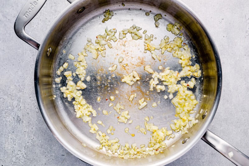 onion and garlic cooking in a stainless skillet.