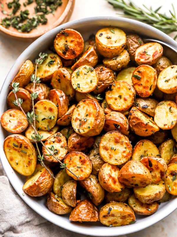 overhead view of roasted potatoes in a white bowl.