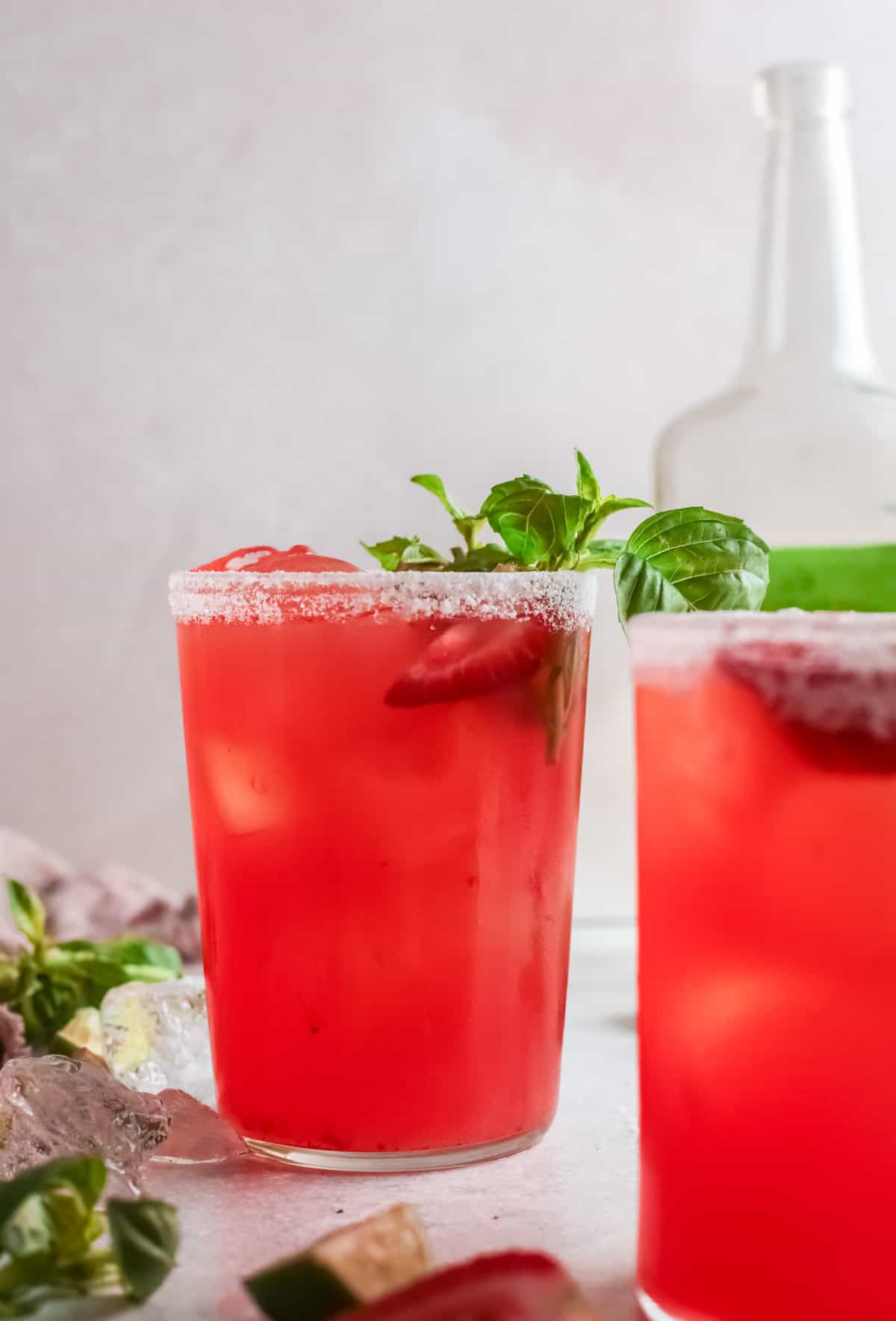 close up of 2 strawberry basil margaritas slightly offset.