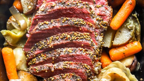 overhead view of sliced crockpot corned beef and cabbage in a crockpot.