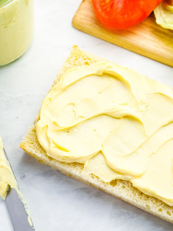 overhead view of mayonnaise slathered on a piece of ciabatta bread.