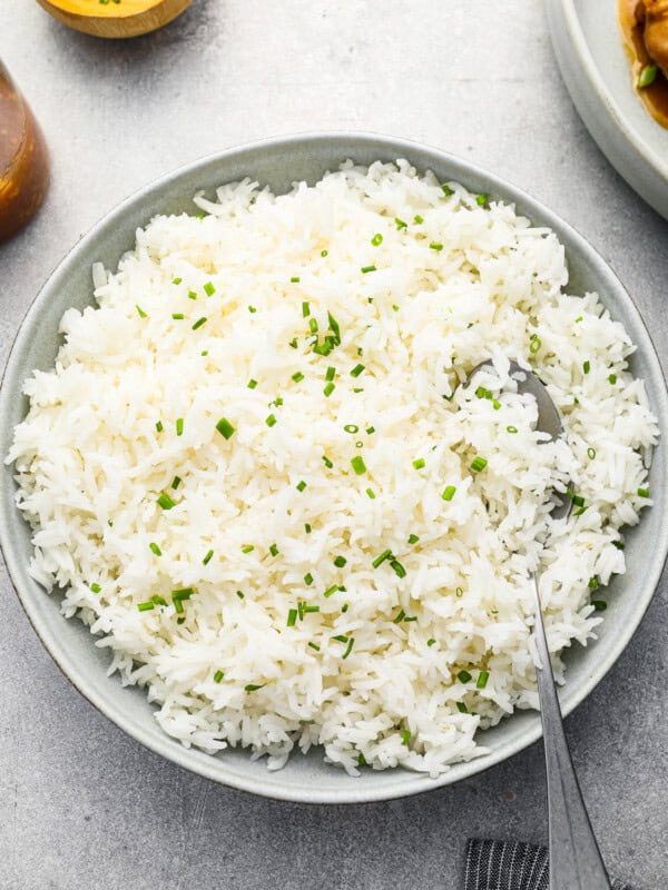 overhead view of stovetop basmati rice in a white bowl with a spoon.