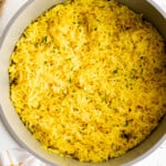 yellow rice in a pan on a table.