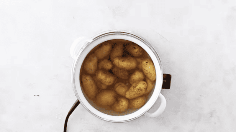 whole potatoes in a pot of water.