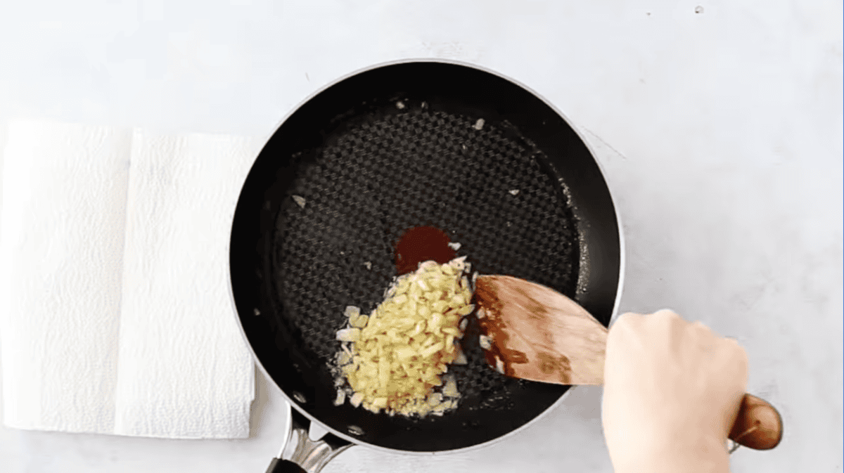sautéed onion in a pan with a wooden spatula.