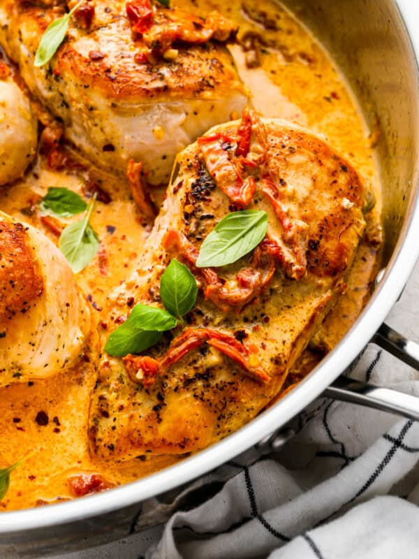 close-up three-quarters view of marry me chicken in a stainless pan.