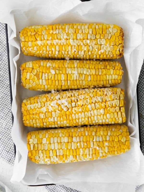 overhead image of 4 ears of corn on the cob on a serving platter