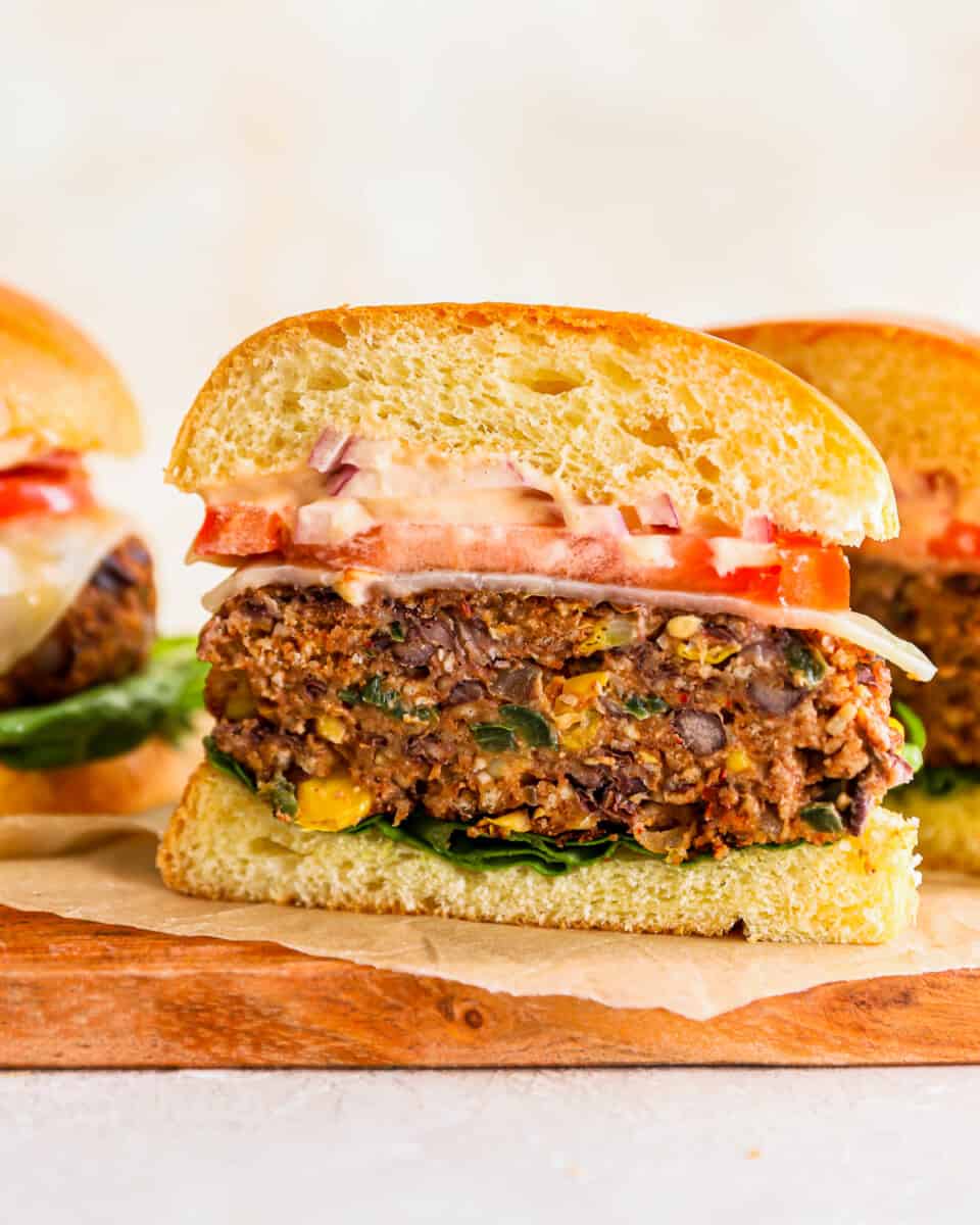 A veggie burger is cut in half to show the black bean patty.