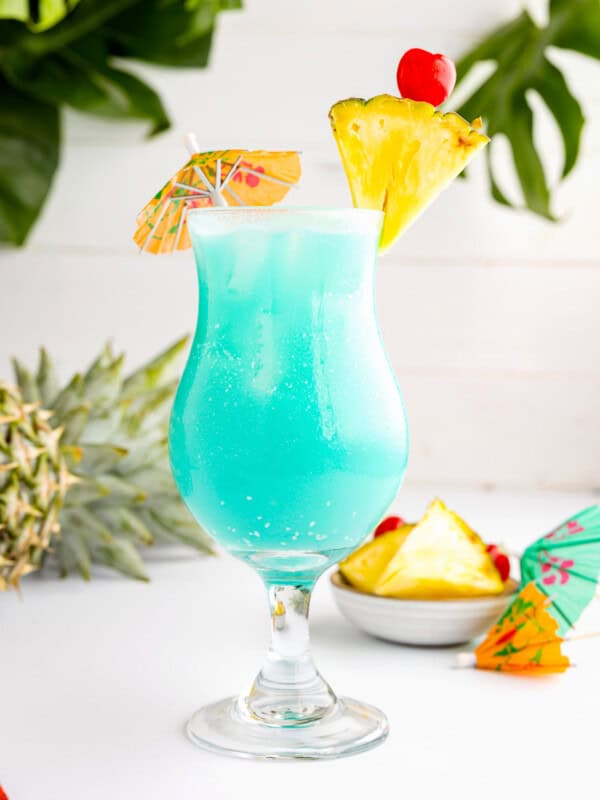 blue hawaiian cocktail with pineapples and umbrellas.