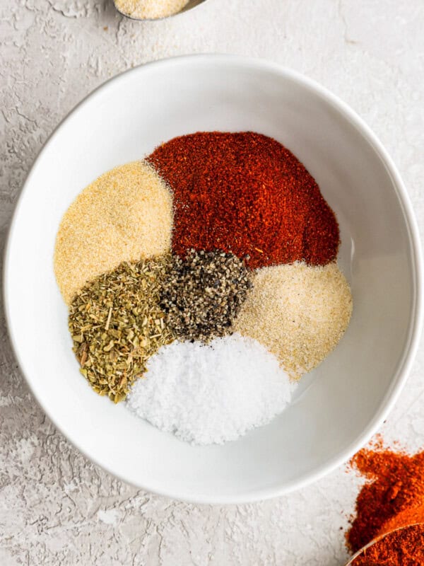 a white bowl filled with spices and seasonings.