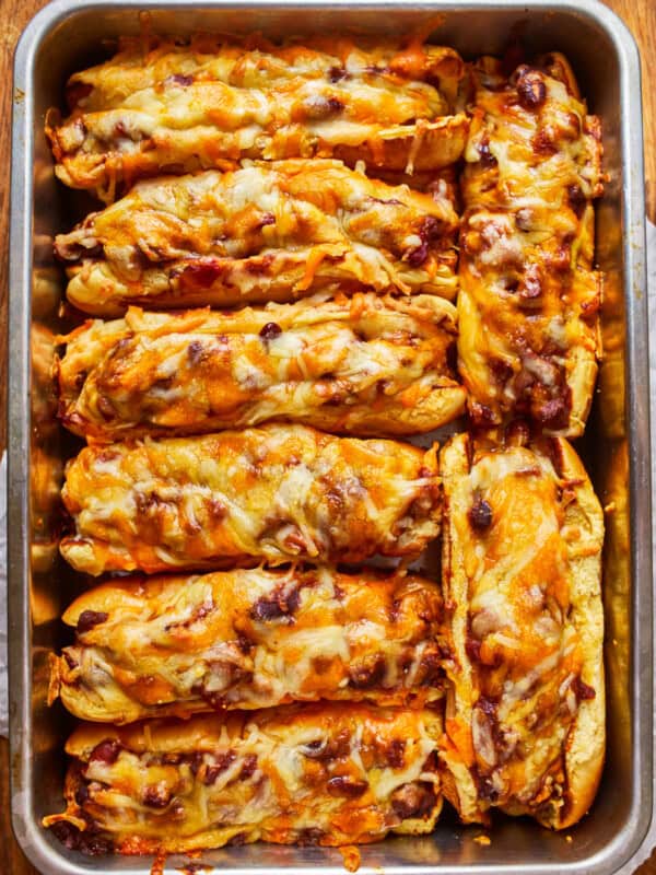 overhead view of 8 chili dogs in a baking pan.