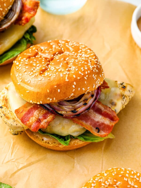 three-quarters view of a grilled chicken sandwich on parchment.