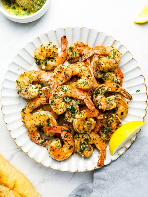 overhead view of grilled shrimp on a white plate.