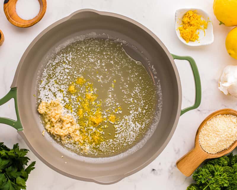 a pan with lemons, parmesan cheese, and other ingredients.