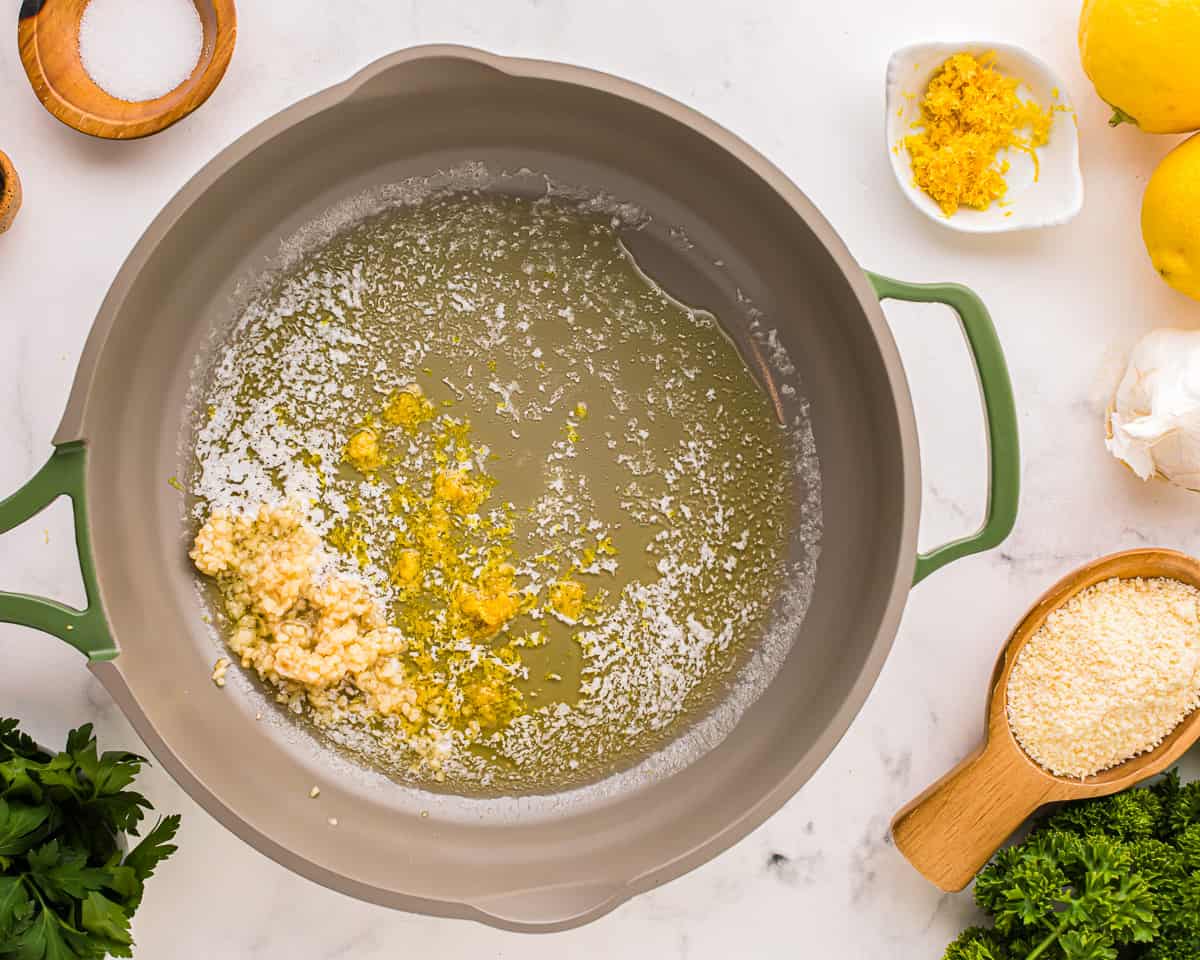 a pan with lemons, parmesan cheese, and other ingredients.