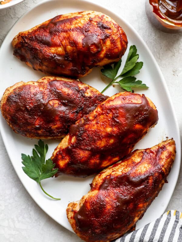 bbq chicken breasts on a white plate.