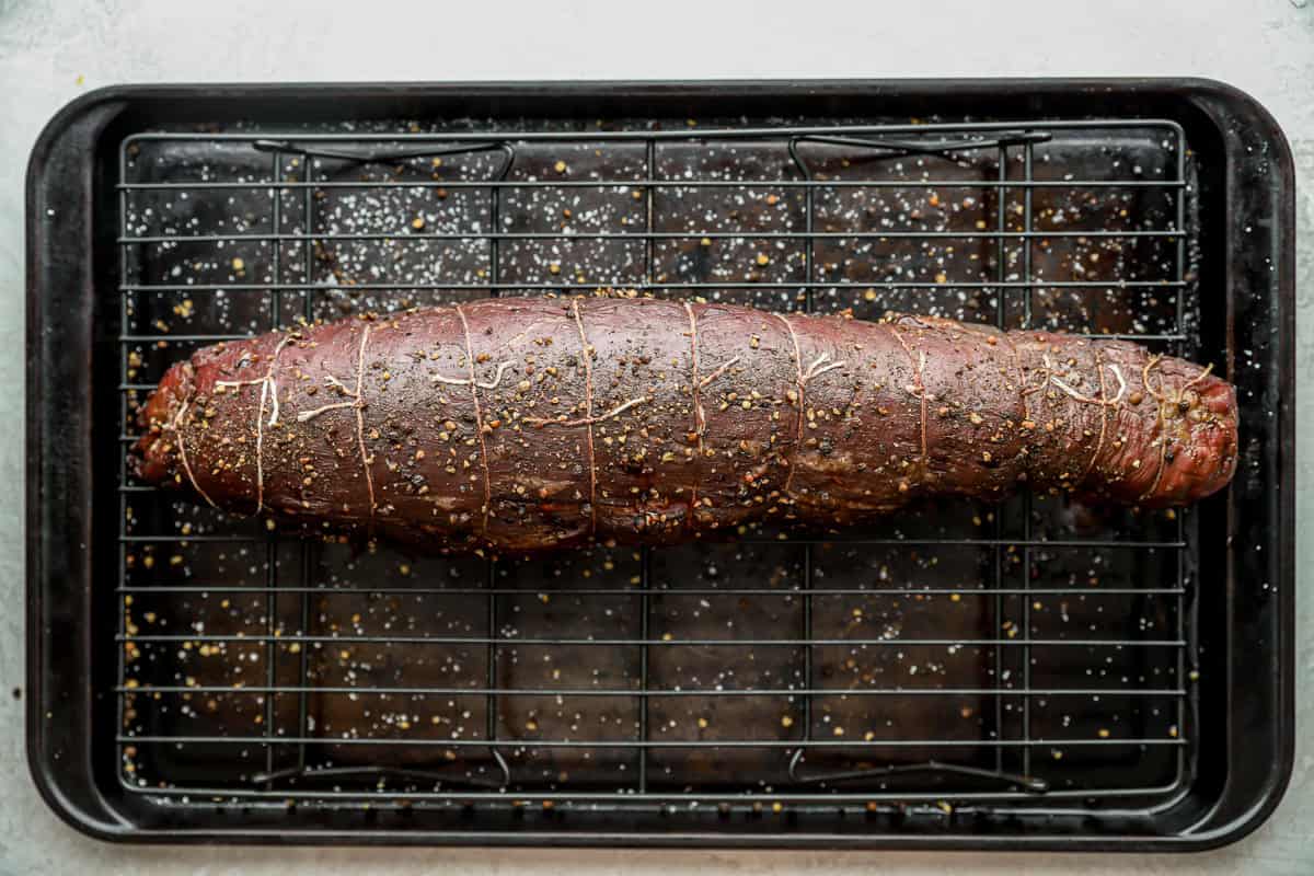 baked tied beef tenderloin on a wire rack set in a baking sheet.