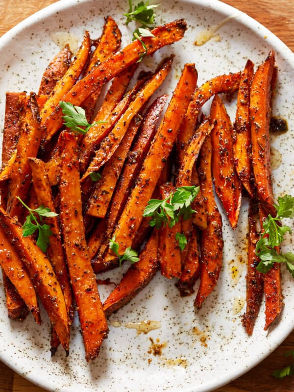 sweet potato fries on a plate with herbs.