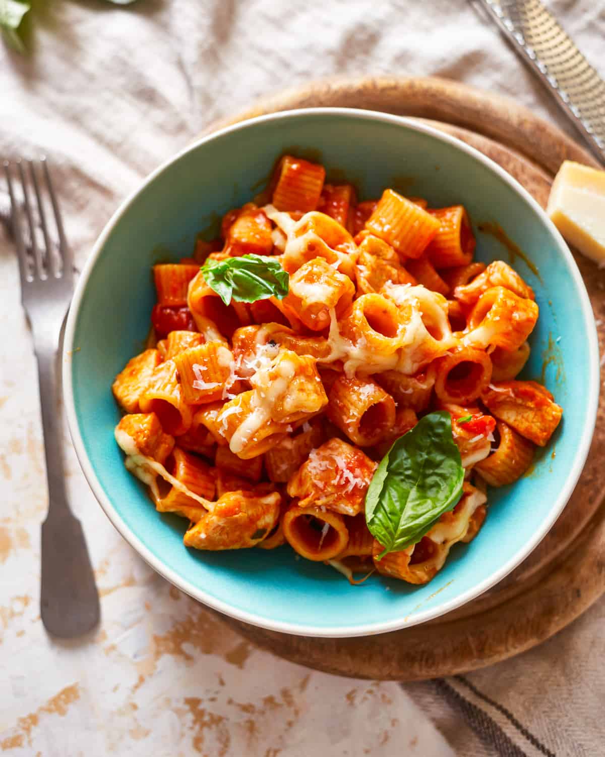 a bowl of pasta with chicken and basil.