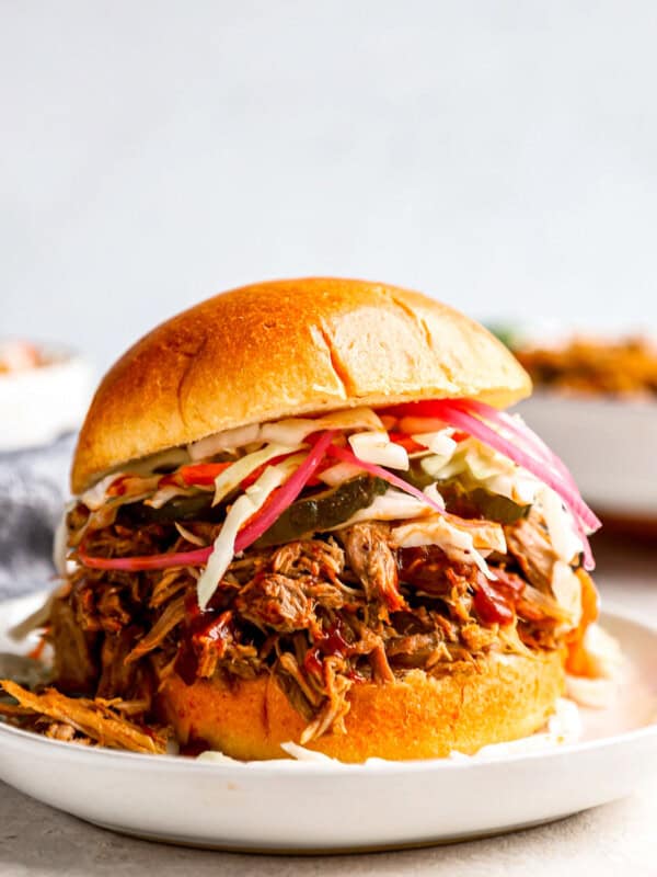 a pulled pork sandwich on a plate with coleslaw.