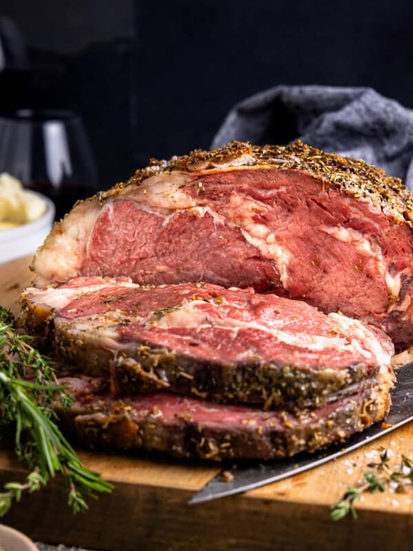 a piece of roast beef on a wooden cutting board.