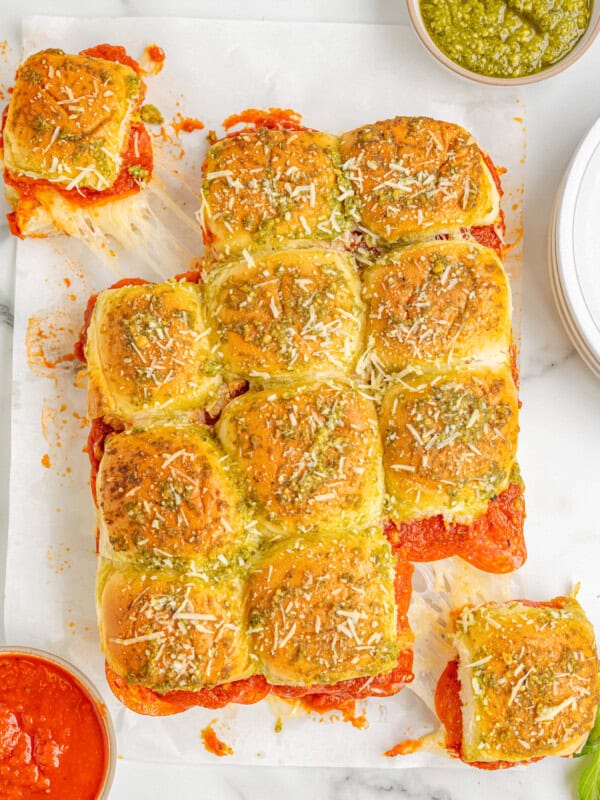 a tray of pizza sliders on a white plate.