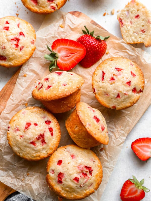 strawberry muffins on a cutting board with strawberries.