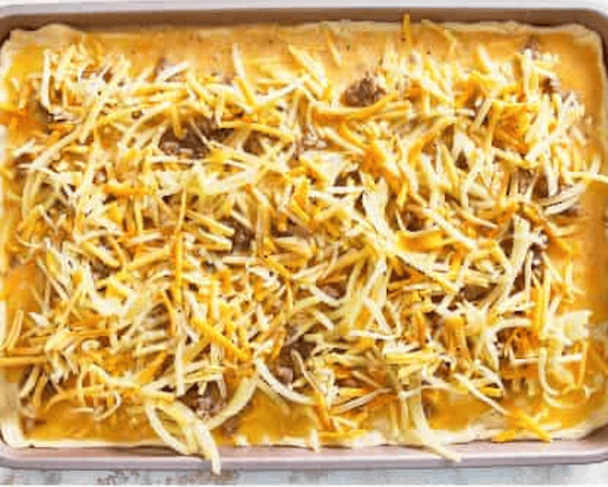 The egg mixture has been poured over the layered ingredients in the baking pan, preparing it for baking.