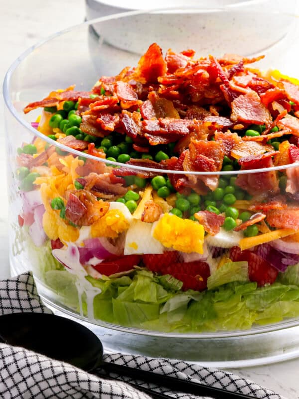 A salad with bacon and peas in a bowl.