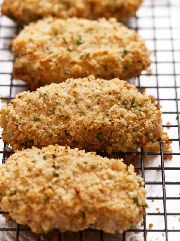 Fried chicken breasts on a cooling rack.