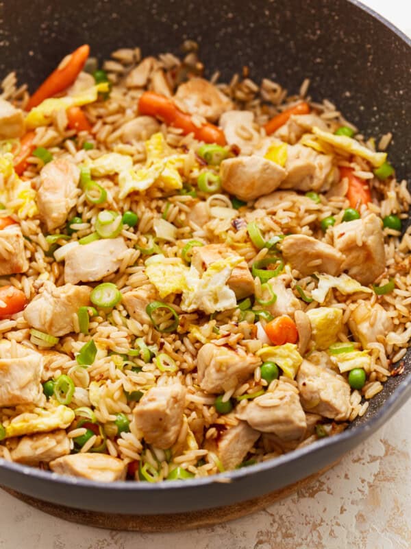 A frying pan filled with chicken and vegetables.