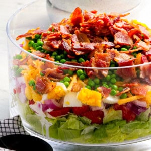 A salad with bacon and peas in a bowl.