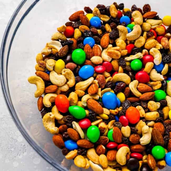 A bowl full of mixed nuts and m&m's.