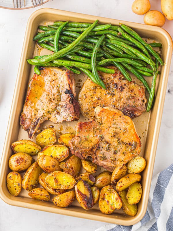 A baking sheet with potatoes and green beans.