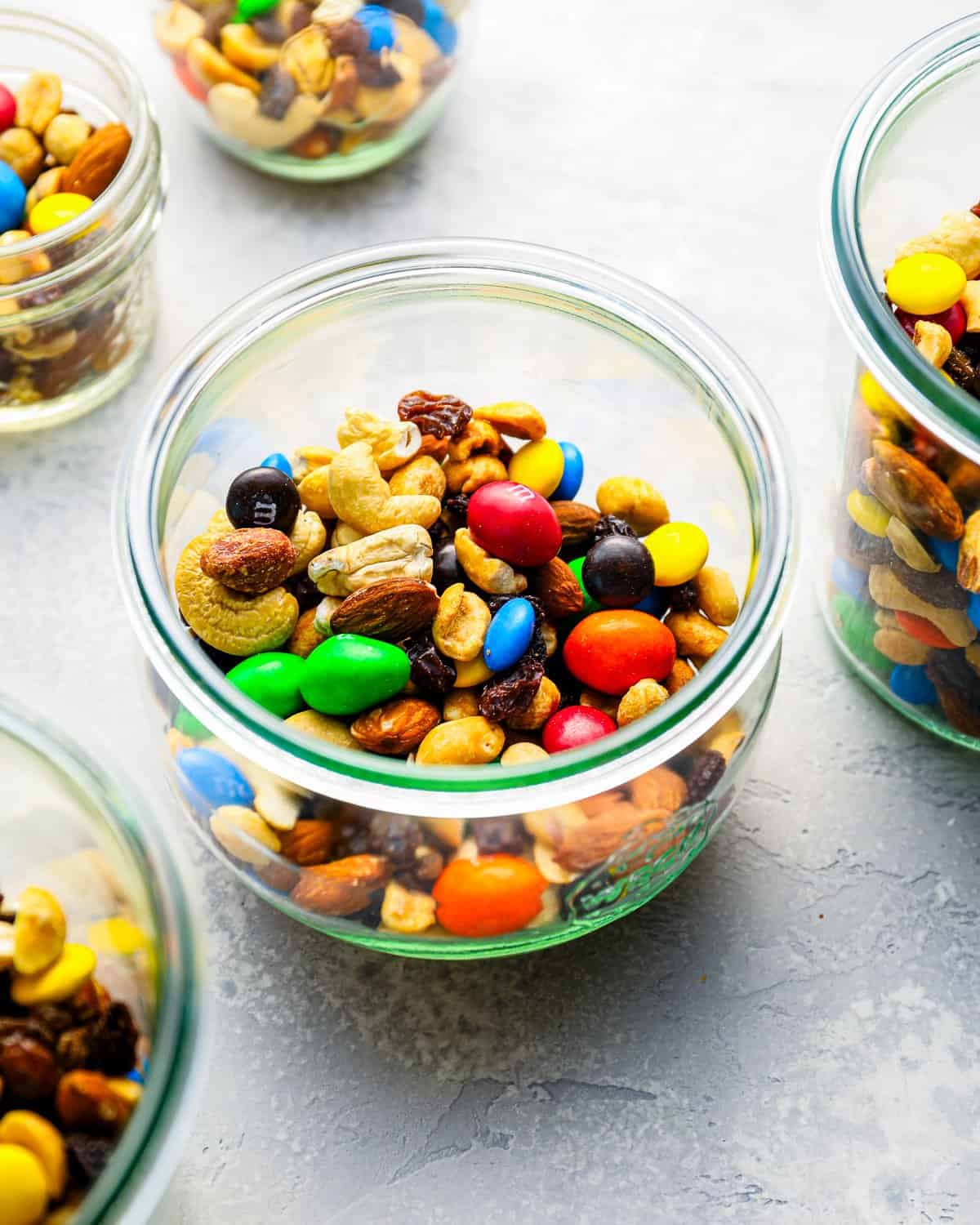 Servings of gorp trail mix in individual glass jars.