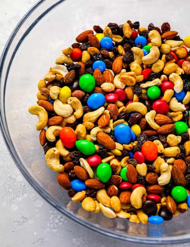 A bowl full of mixed nuts and m&m's.