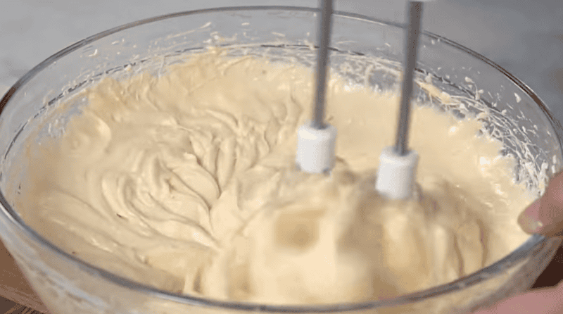 beating caramel apple dip with a hand mixer.