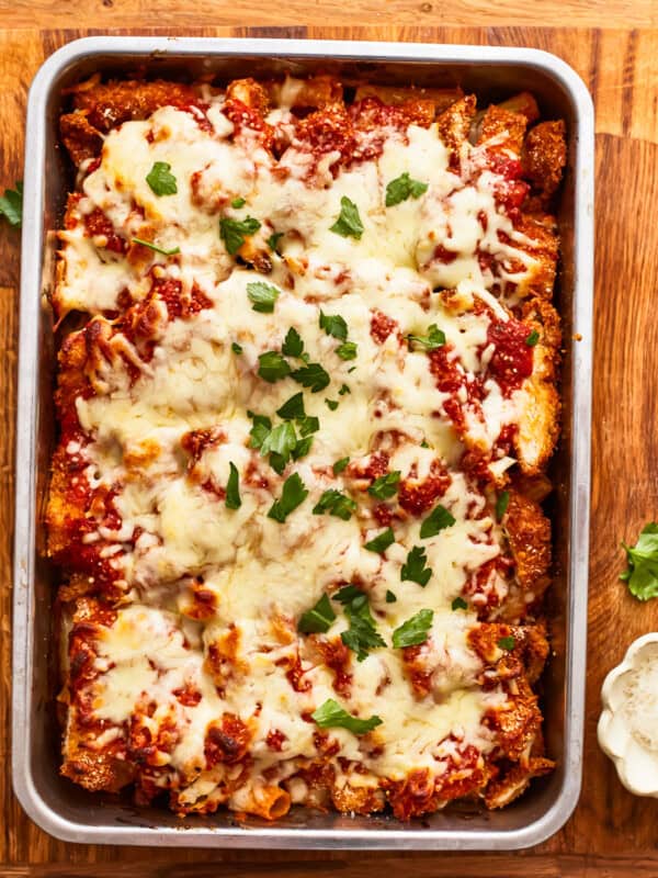 Lasagna in a baking dish with cheese and parmesan.