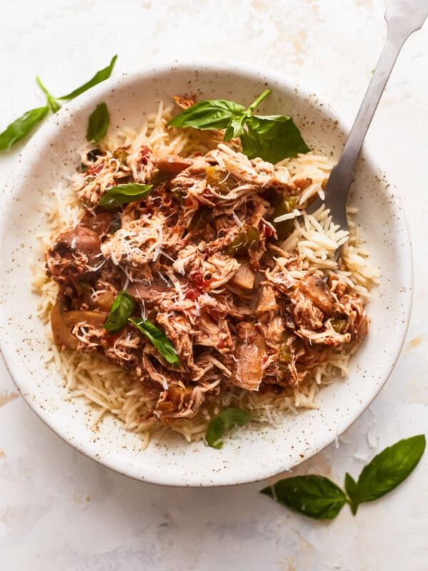 A white bowl with rice and meat in it.