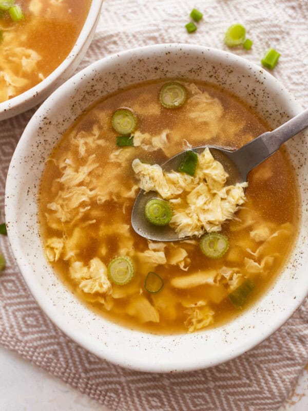 Two bowls of asian noodle soup with a spoon.