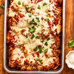 Lasagna in a baking dish with cheese and parmesan.