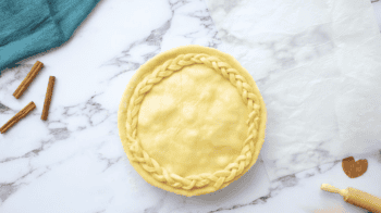 apple pie covered with a top crust with a braid detail.