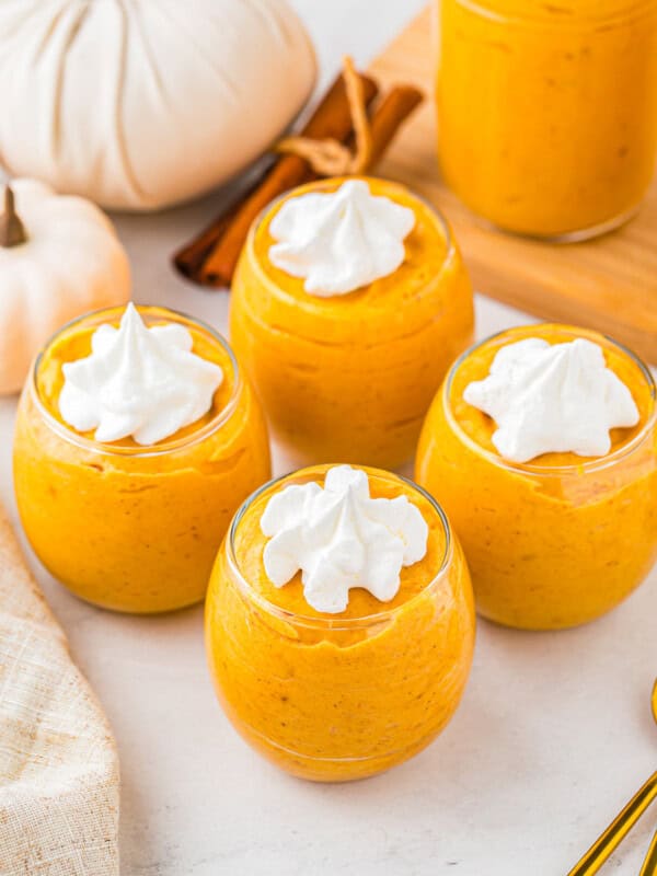 Pumpkin pudding in jars with whipped cream on top.