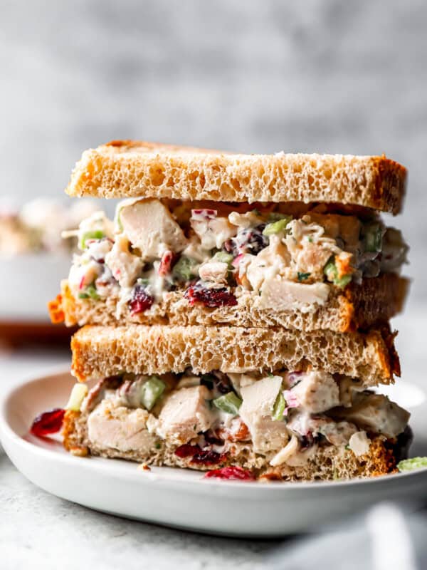 A stack of turkey salad sandwiches on a plate.