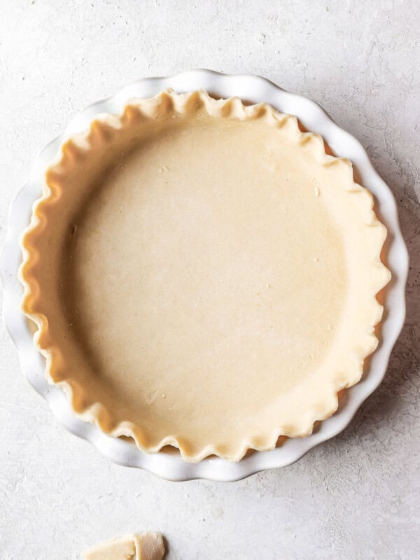 A pie crust in a white pie plate.