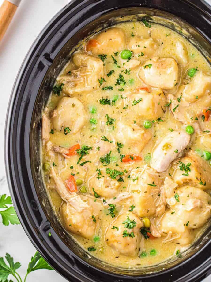 crockpot chicken and dumplings garnished with parsley.