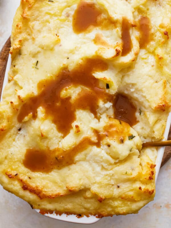 a dish of make ahead mashed potatoes topped with gravy.